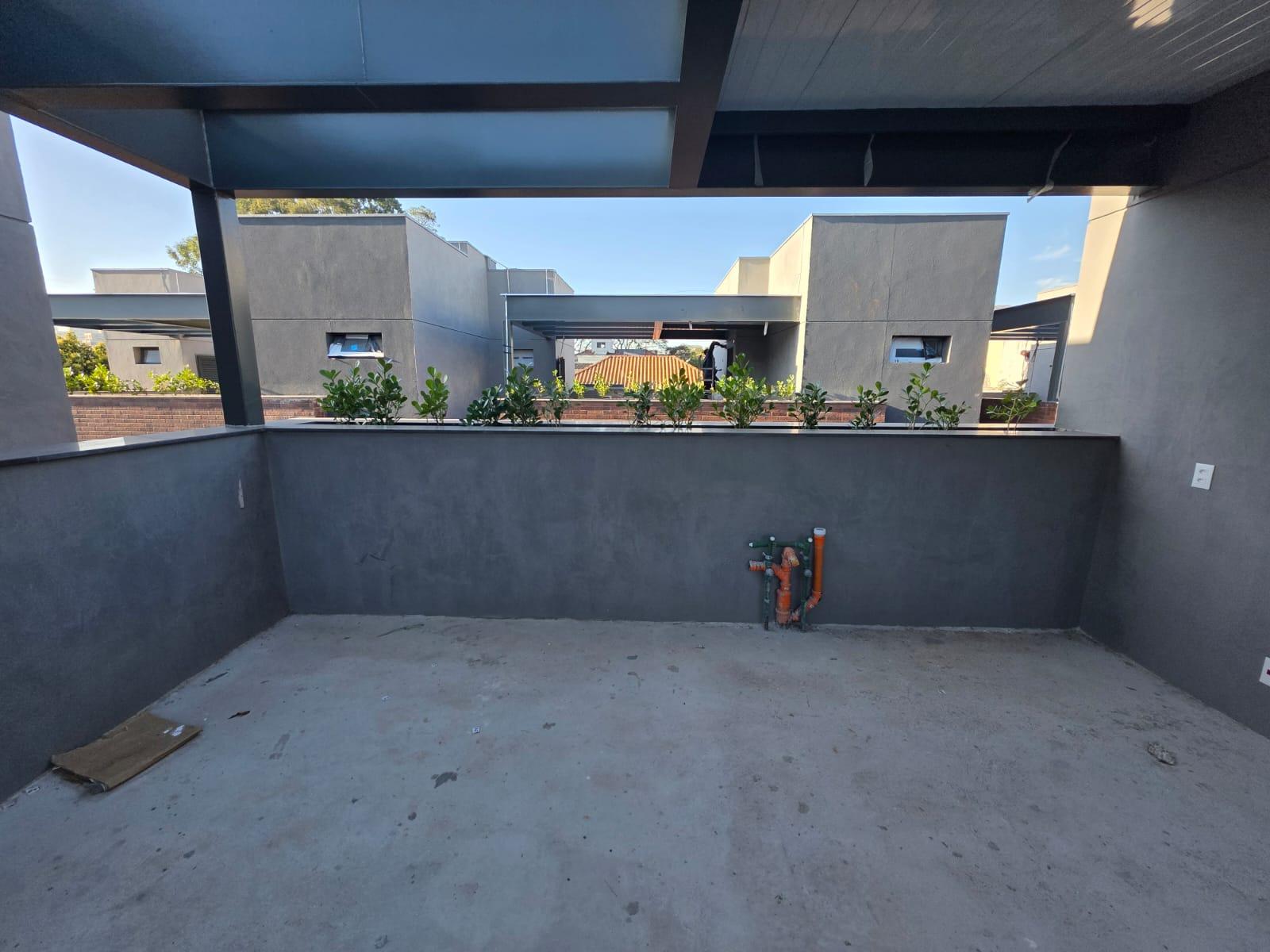 Terraço com pergolado metálico e jardineiras