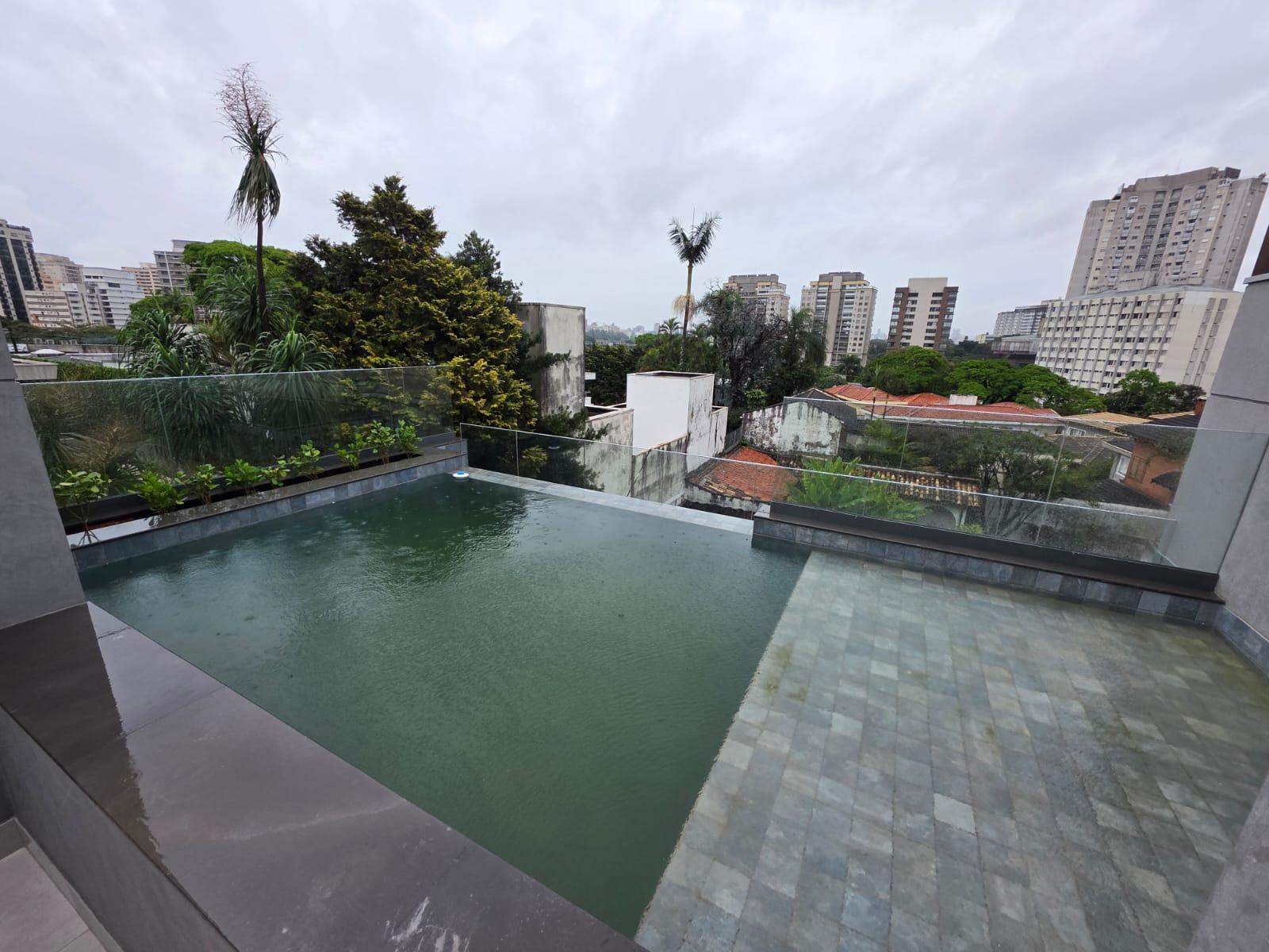 Piscina em rooftop com deck e vista da cidade