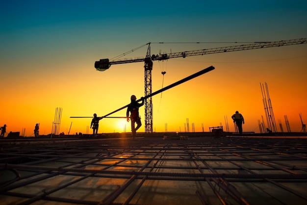 Canteiro de obras ao pôr do sol com equipe em atividade